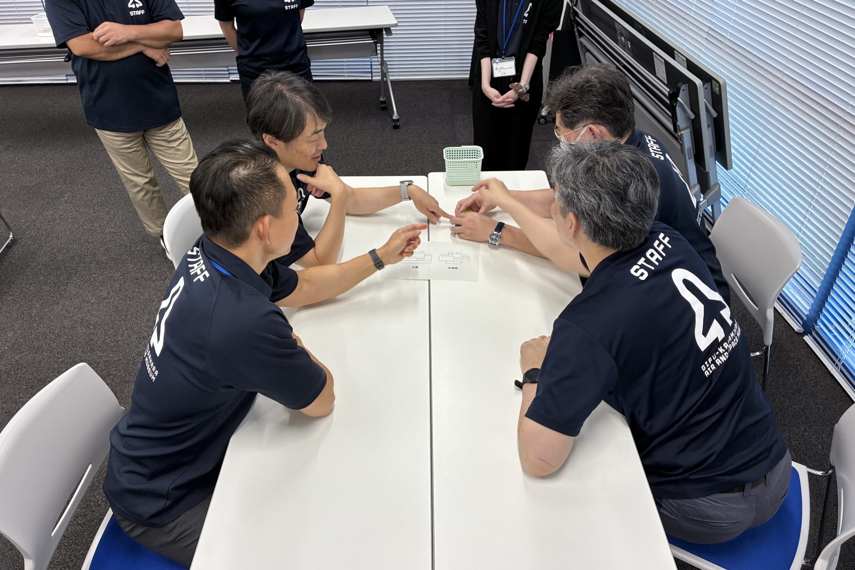 小学校団体向けのブロックパズルに取り組む職員の写真