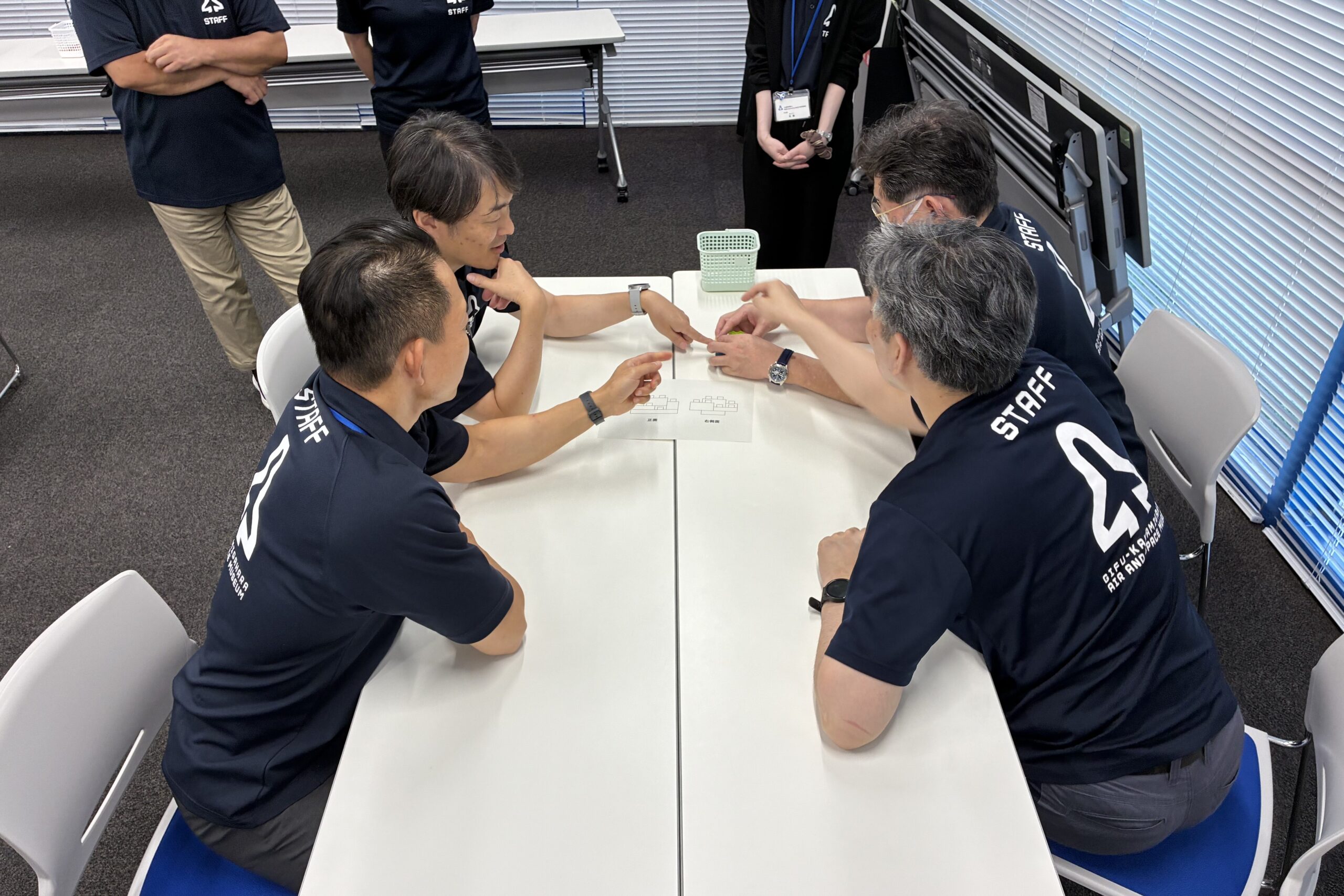 小学校団体向けのブロックパズルに取り組む職員の写真